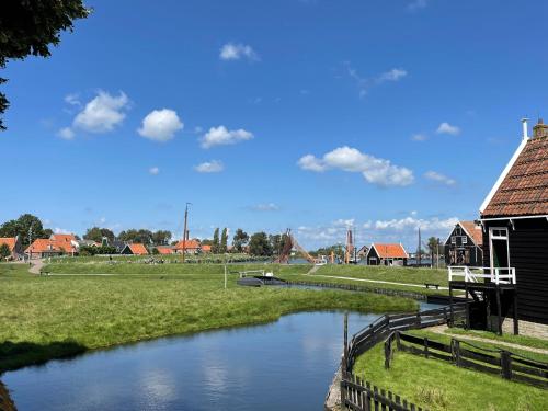 a river next to a building and a house at Hotelhuisjes Medemblik in Wieringerwerf