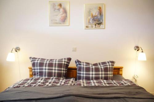 - un lit avec 2 oreillers et 2 photos sur le mur dans l'établissement Ferienwohnung am Oberen Schloss, à Siegen