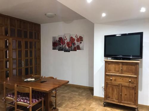 un soggiorno con TV e tavolo in legno di Casa La Quercia a Chiusi della Verna