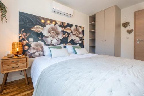 a bedroom with a large bed with a floral wall at LA P'TITE EVASION in Heimsbrunn