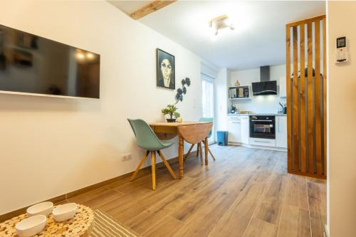 une cuisine et une salle à manger avec une table et des chaises dans l'établissement LA P'TITE EVASION, à Heimsbrunn