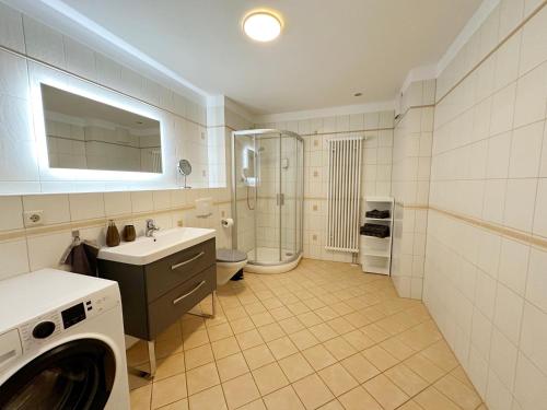 a bathroom with a sink and a washing machine at Quartier Victoria - Souterrain Am Goethepark in Weimar