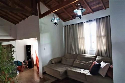 a living room with a couch and a window at Bem-estar e boa localização (Apto Paraíso) in Maringá