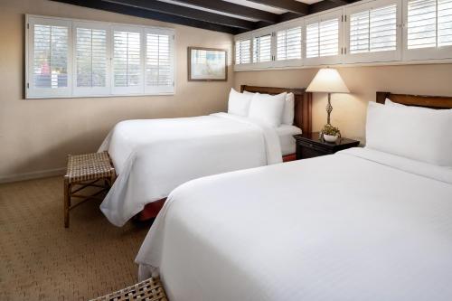 a hotel room with two beds and a chair at La Casa Del Zorro Resort & Spa in Borrego Springs
