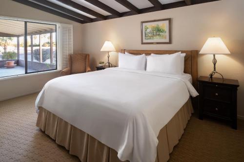 Cette chambre comprend un grand lit blanc et une fenêtre. dans l'établissement La Casa Del Zorro Resort & Spa, à Borrego Springs
