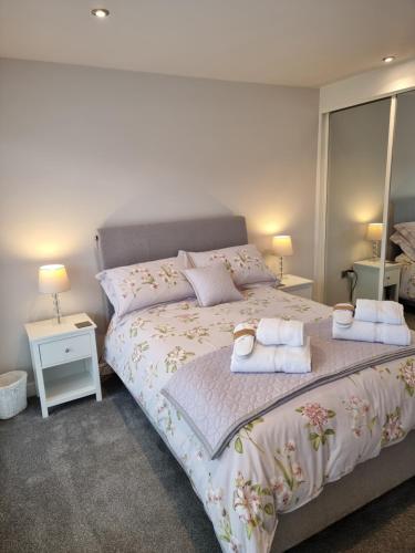 a bedroom with a large bed with towels on it at Begonia Cottage in Briston