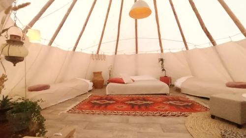 a room with a bed and a rug in a yurt at Wigwam in Roodhuis