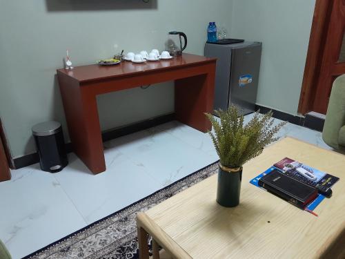 a living room with a table and a table with a vase at HOTEL MDOPE MBEYA in Mbeya