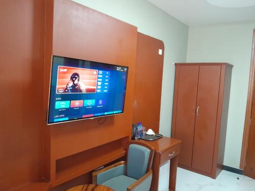 a room with a flat screen tv on a wall at HOTEL MDOPE MBEYA in Mbeya