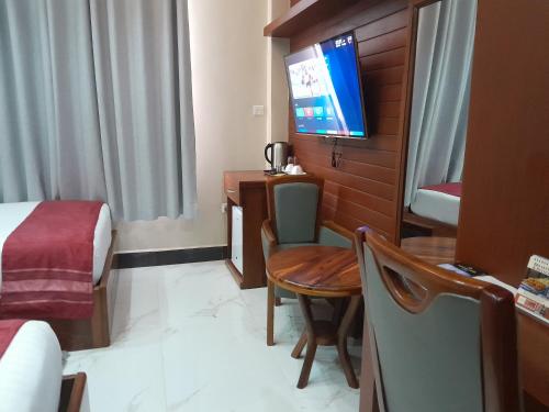 a hotel room with a bed and a television at HOTEL MDOPE MBEYA in Mbeya