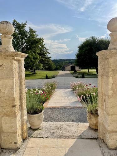 une entrée d'une maison avec deux pots de fleurs dans l'établissement Chateau Masburel, à Fougueyrolles