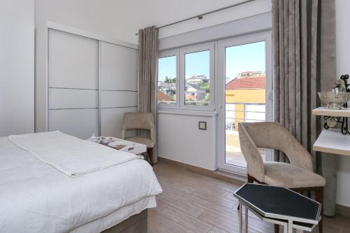 a bedroom with a bed and a desk and a window at Apartment Jasmin - Amazing Seaview Maisonette with direct beach access in Rtina