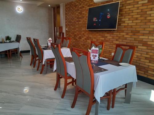 a dining room with tables and chairs and a wall at HOTEL MDOPE MBEYA in Mbeya