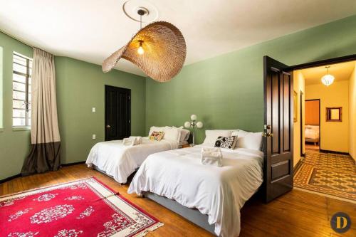 2 camas en una habitación con paredes verdes en 102 Amplio y elegante estilo Art Déco, en Ciudad de México