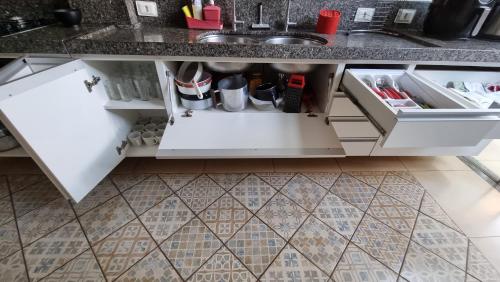 a kitchen with white cabinets and a sink at Casa Carandá in Campo Grande