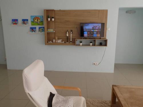a living room with a white chair and a tv at Villa Favvidae ~ Close to Beach in Jan Thiel