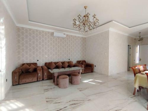 uma sala de estar com mobiliário de couro e um lustre em Apartaments Hayat em Guiumri