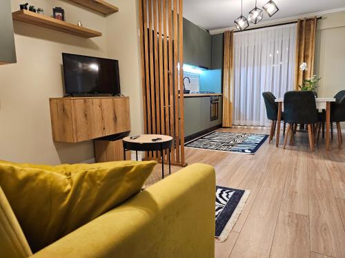 a living room with a couch and a dining room at Urban Deluxe Retreat Coposu in Cluj-Napoca