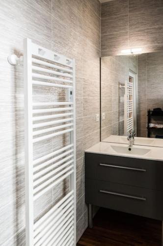 une salle de bain avec un lavabo et un miroir dans l'établissement La Bastide avec piscine privée, pétanque et climatisation, à Cours-de-Pile