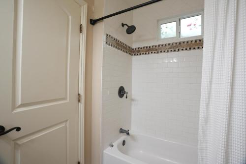 a bathroom with a white tub and a window at Destination #03 in Fullerton