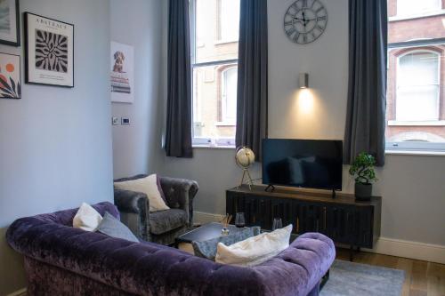 a living room with a purple couch and a tv at Flat in Nottingham City Centre in Nottingham