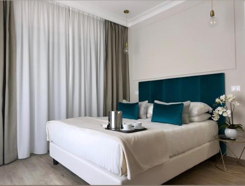 Un dormitorio con una gran cama blanca con toques azules en NLM Boutique Suites, en Roma