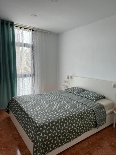 una camera da letto con un letto e una finestra di las Piteras ad Arona