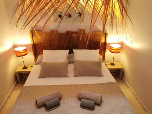 ein Schlafzimmer mit einem großen Bett mit zwei Lampen in der Unterkunft LES BOHEMIELLES 4**** Cottage MARTIN in Cartelègue