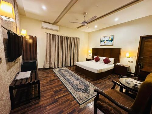 um quarto com uma cama e uma sala de estar em Shelton’s Rezidor Lahore em Lahore