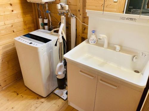 a bathroom with a sink and a washing machine at Shirakaba no mori Cottage - Vacation STAY 90522v in Abashiri