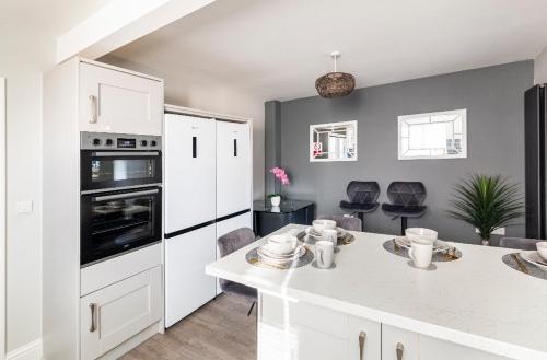 cocina con armarios blancos y encimera blanca en Luxury house with 4 ensuite bedrooms, free parking Wifi, en Oxford