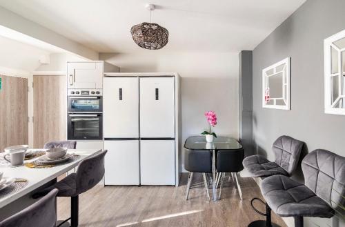 a kitchen with a white refrigerator and a table and chairs at Luxury House 4 ensuite bedrooms, free parking ,wifi in Oxford