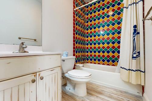 a bathroom with a toilet and a shower curtain at Pleasant Tides in St. George Island
