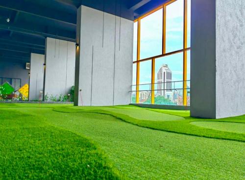 a large building with green grass and large windows at Grand Residence Suite At Opus Kuala Lumpur in Kuala Lumpur