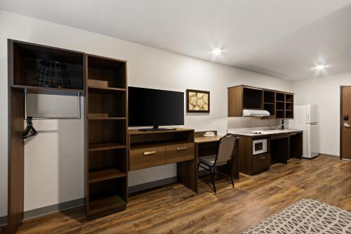 a room with a desk with a computer and a monitor at WoodSpring Suites Tolleson - Phoenix West in Avondale