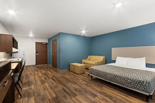 a bedroom with a bed and a desk and a chair at WoodSpring Suites Tolleson - Phoenix West in Avondale