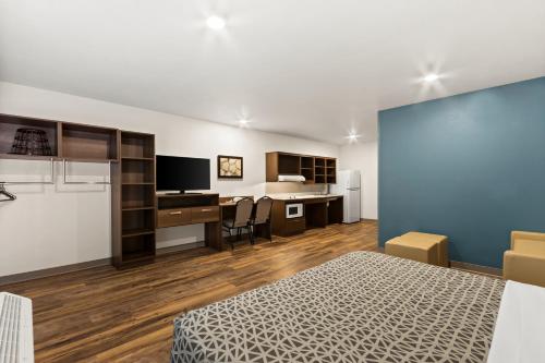 a room with a bed and a desk with a computer at WoodSpring Suites Tolleson - Phoenix West in Avondale