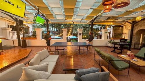 two people standing in a room with a table and chairs at Viajero Quito Hostel in Quito