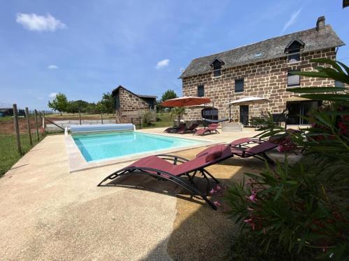 une maison avec une piscine à côté d'un bâtiment dans l'établissement Gîte de France Le grand cluzel 4 épis - Gîte de France 8 personnes MAE-9554, à Saint-Cyr-la-Roche