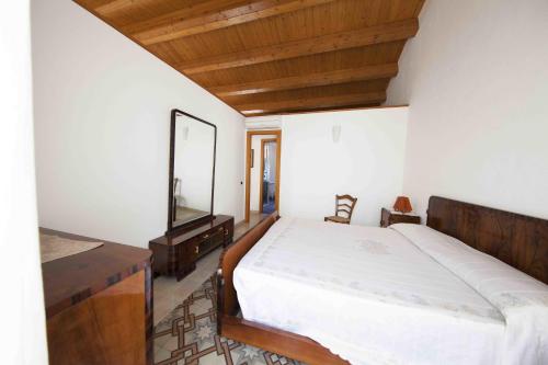 1 dormitorio con 1 cama grande y espejo en Gioeni Apartment, en Cefalú