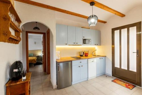 a kitchen with white cabinets and a stainless steel refrigerator at Apartament in Monte Pedreguer in Pedreguer