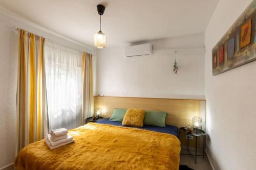 Apartament in Monte Pedreguer في بيدريجوير: غرفة نوم بسرير كبير مع بطانية صفراء