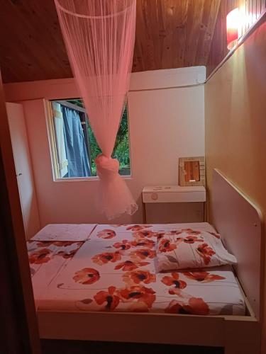 una camera da letto con un letto fiorito di La petite perle a Ducos