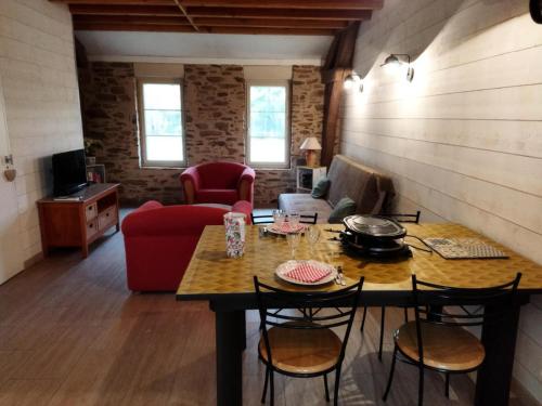 a living room with a table and chairs and a couch at Gîte de France C'est tout vert 4 épis - Gîte de France 5 personnes MAE-9824 in Condat-sur-Ganaveix