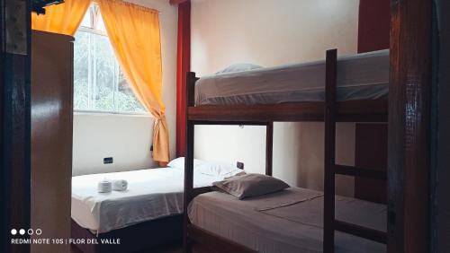 a bedroom with two bunk beds and a window at Hostel Flor del Valle in Tarapoto