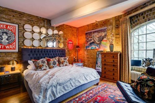 a bedroom with a bed and a brick wall at Luxury Bermondsey Warehouse Loft with Lift in London