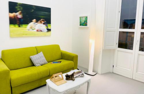 a living room with a green couch and a table at 1881 Artistic Royal House in Caserta