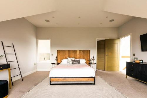 a bedroom with a bed and a flat screen tv at Luxury Home with Garden, Gym, Free Parking & Roof Terrace! in Batheaston
