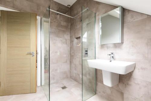 a bathroom with a sink and a glass shower at Luxury Home with Garden, Gym, Free Parking & Roof Terrace! in Batheaston