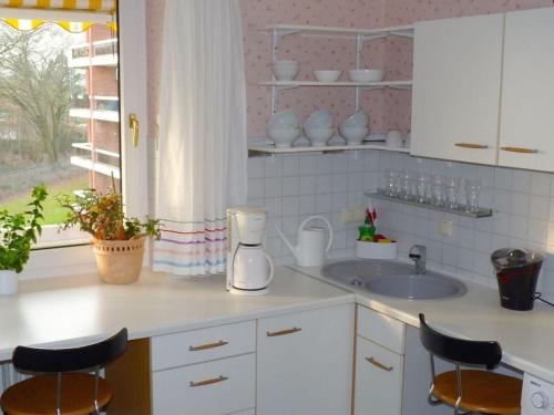 a kitchen with a sink and a counter with stools at Holiday apartment Schramm in Bargteheide